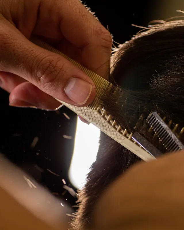 Pente atravessando mecha de cabelo em luz natural