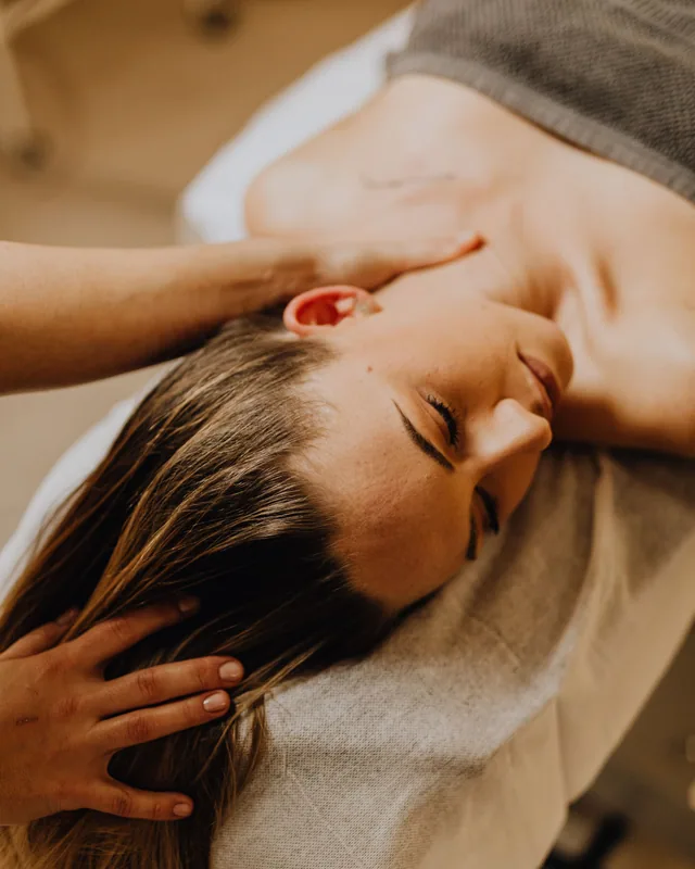 Mãos massageando o couro cabeludo durante sessão de head spa